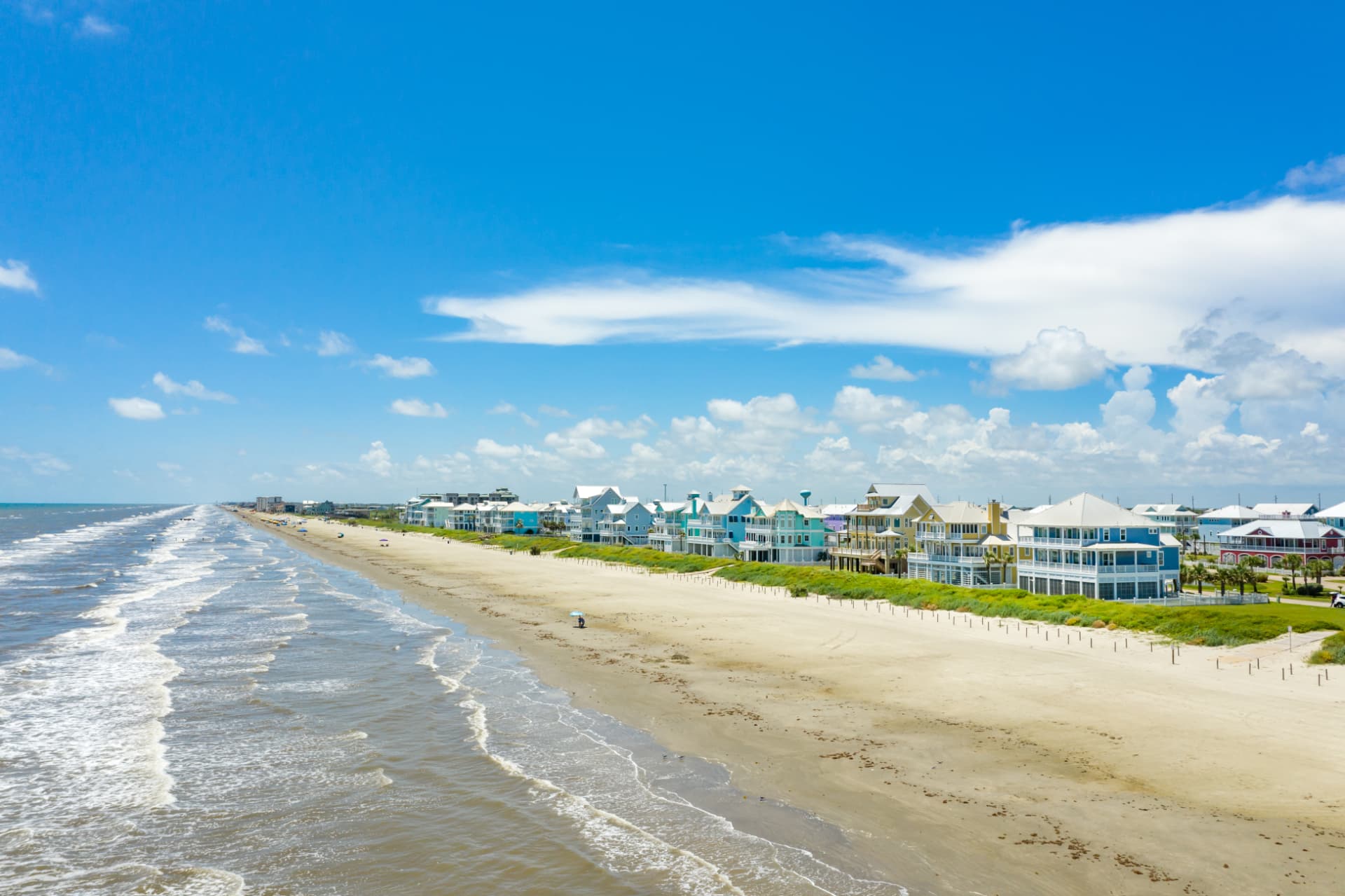 Aerial view of colorful beachfront homes and Gulf surf along Galveston Island, Texas