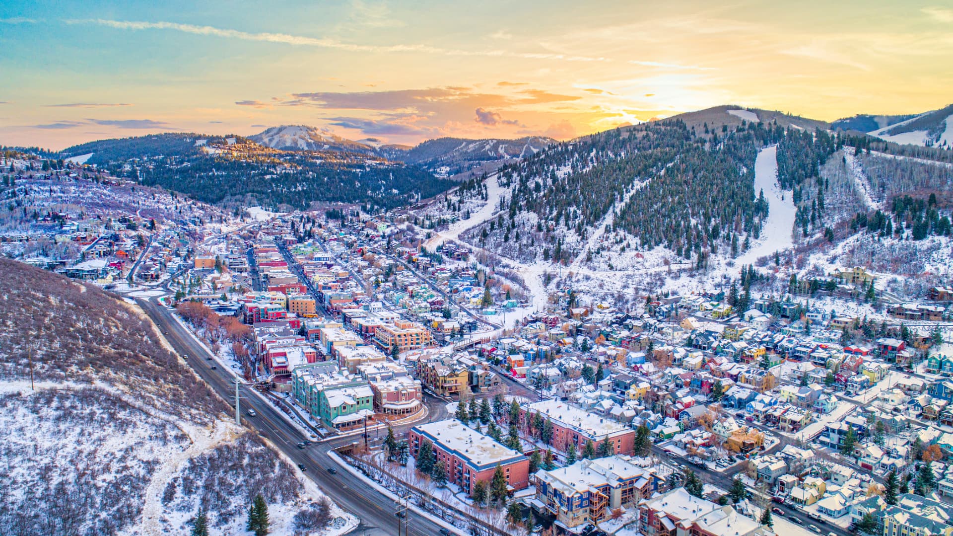 Aerial view of snow-covered ski runs above the town of Park City, Utah, at sunset